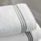 Elegant white towels with gray stripes, perfect for modern bathroom decor.