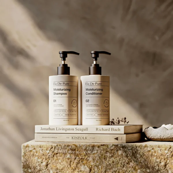 Stylish display of moisturizing shampoo and conditioner on books in neutral tones.