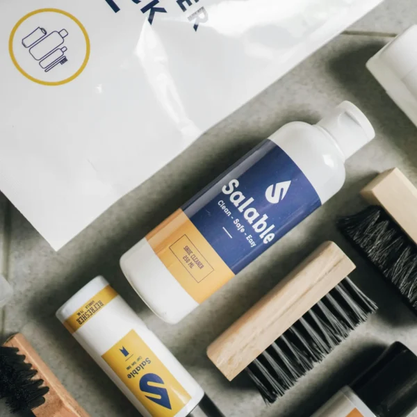 Flat lay of eco-friendly cleaning products and brushes showcasing minimalist packaging.